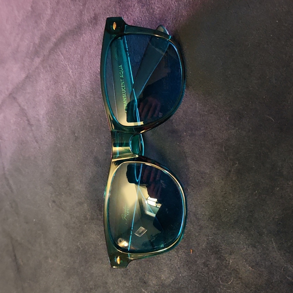 Teal sunglasses with green lenses